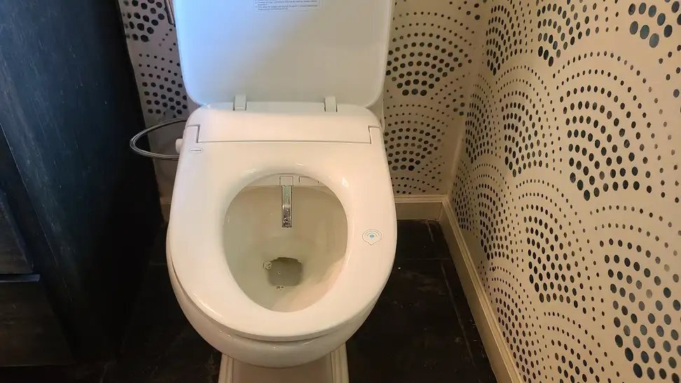 A modern Alpha Bidet UX Pearl seat installed on a clean bathroom toilet.