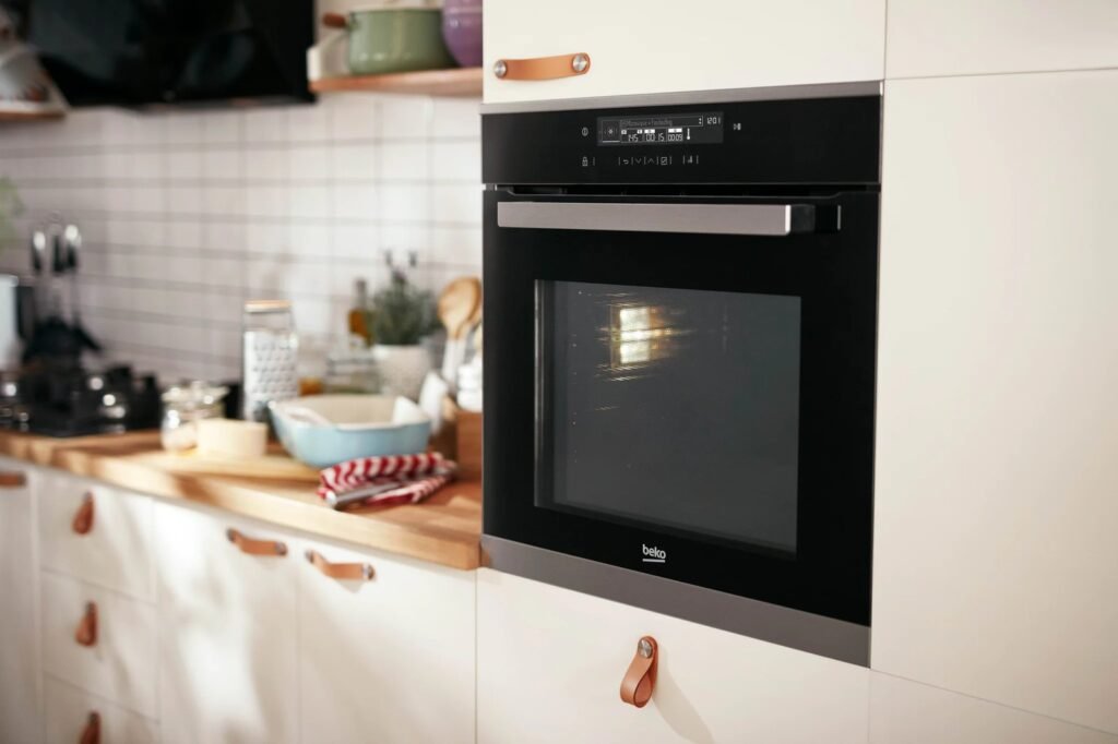 A modern kitchen interior showing a built-in oven versus a freestanding oven.