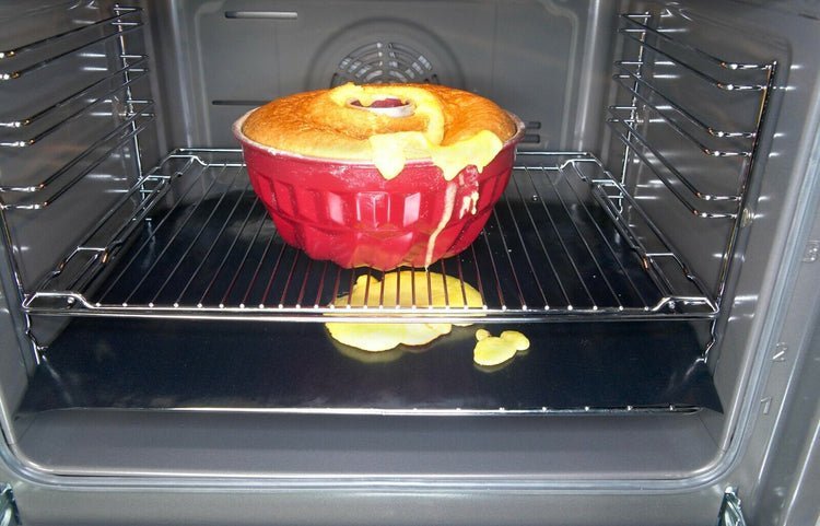 A person carefully installing a protective liner in their clean electric oven.