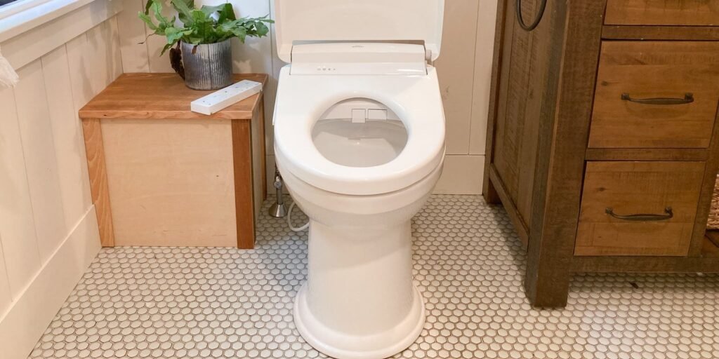 A modern bidet toilet seat installed in a bright and minimalist contemporary bathroom.