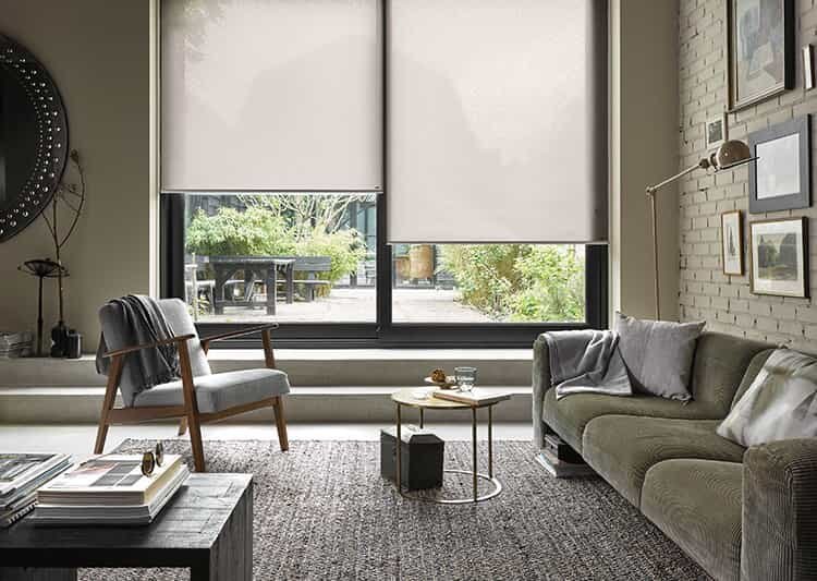 Modern living room with cellular shades installed on large sliding glass windows.