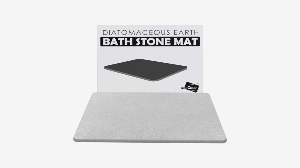 A modern diatomaceous earth bath mat sits on a wooden bathroom floor.