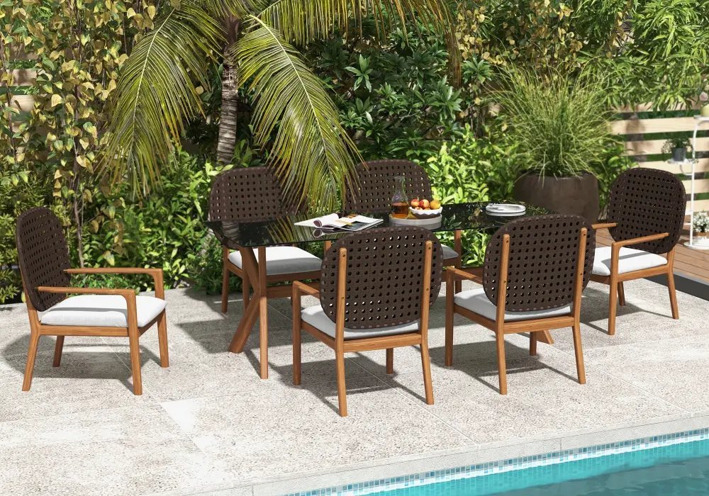 A beautifully maintained teak wood table sits on a sunlit patio outdoors.