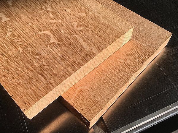 Applying a natural finish to white oak wood on a workshop workbench.