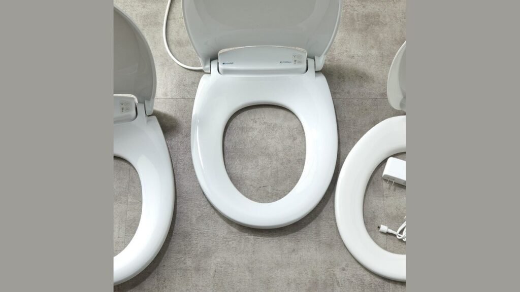 A modern heated toilet seat installed in a bright, clean, and minimalist bathroom.