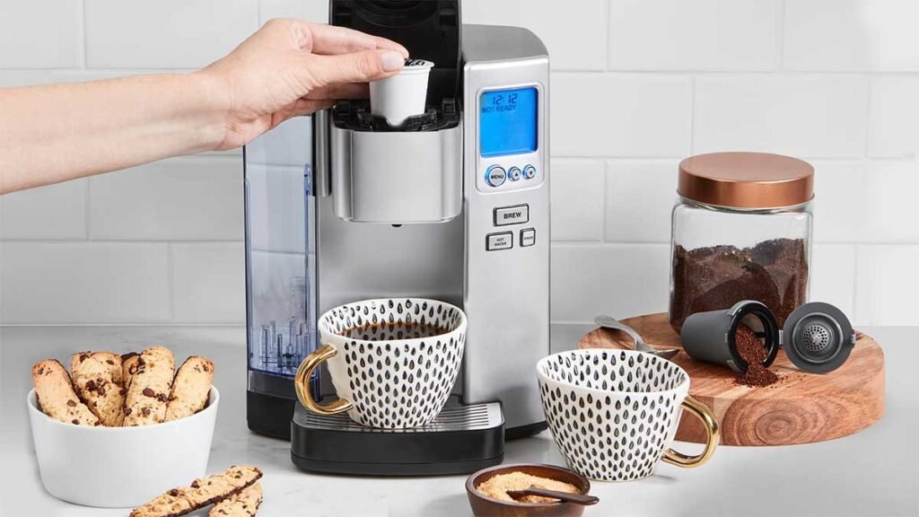 A modern coffee maker sits on a kitchen counter with a steaming mug.
