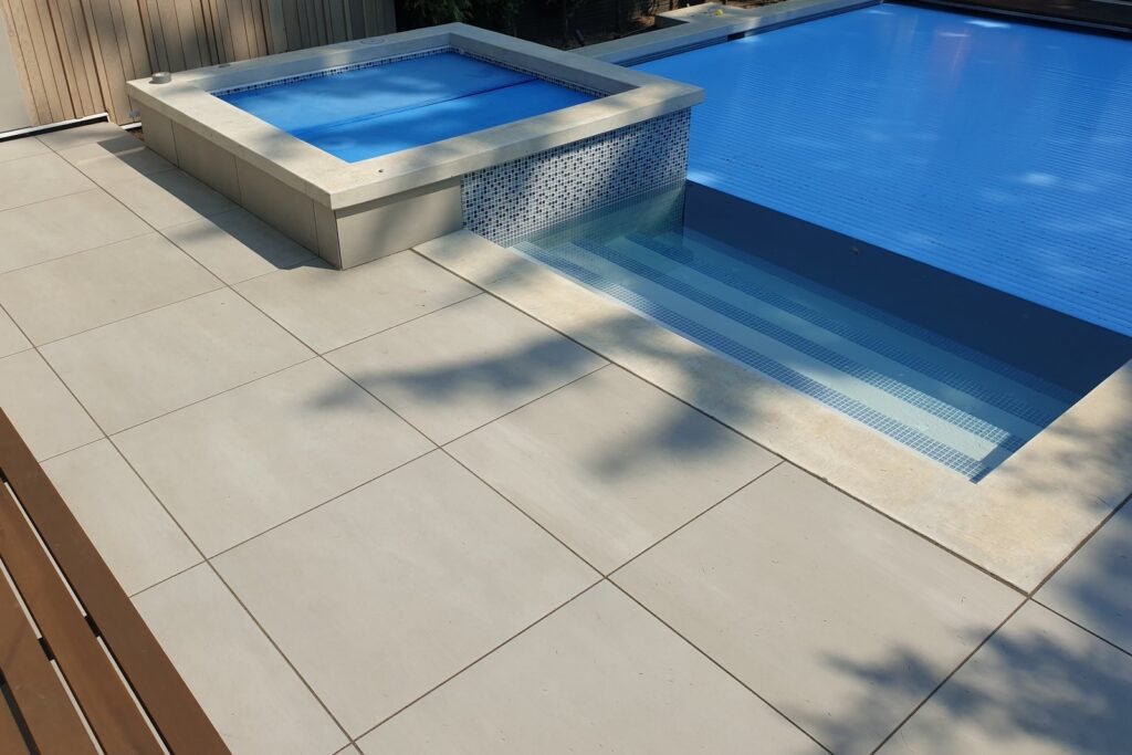 A professional mason applying the best mortar for pool coping to secure stone tiles.