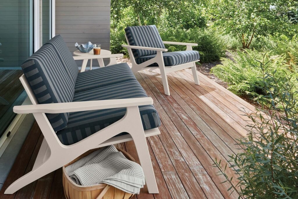 A spacious outdoor sofa set arranged elegantly on a sunny modern stone patio.