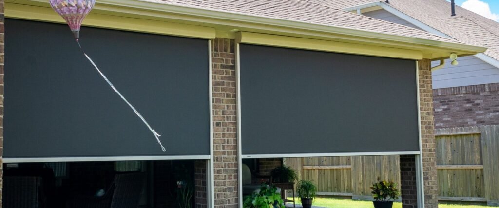 A modern wind-resistant patio cover providing shade on a breezy outdoor terrace.