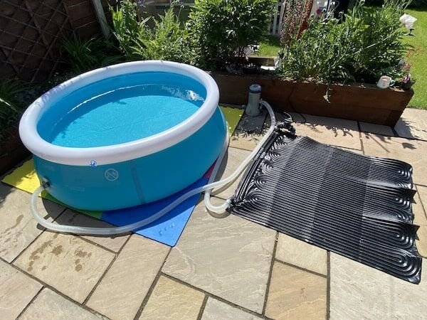A high-efficiency pool pump installed next to a clean Intex above-ground swimming pool.