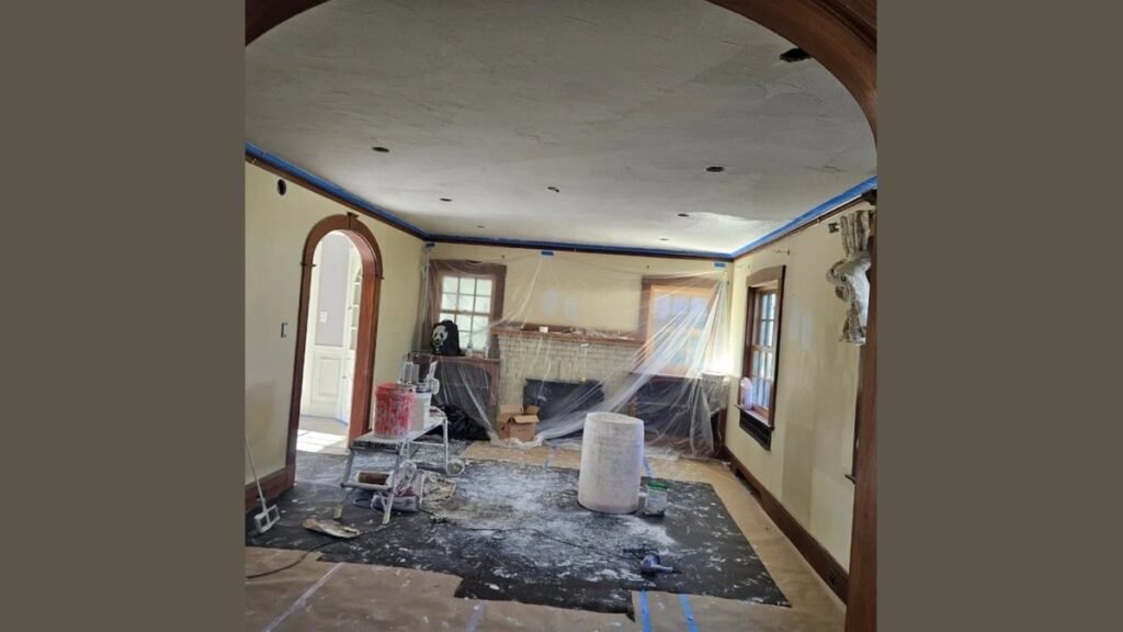 A professional painter applies the best primer for new plaster walls in a bright room.