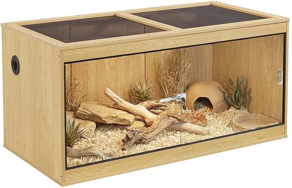 A modern glass reptile tank with sliding doors displayed in a bright home interior.