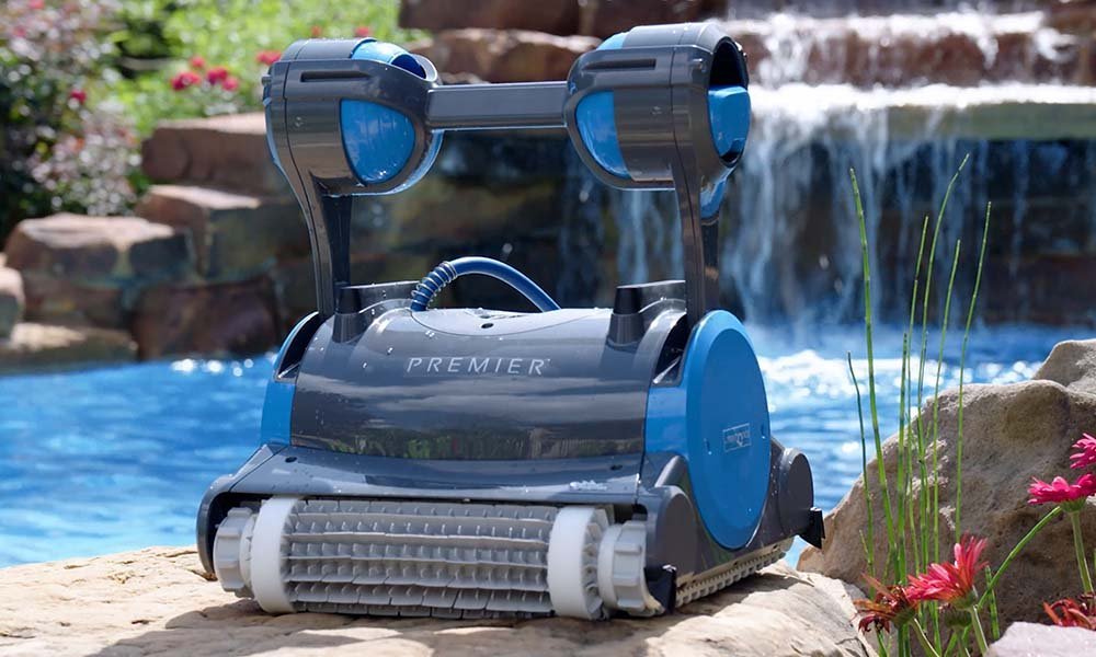 A modern robotic pool cleaner resting on the floor of a clear swimming pool.