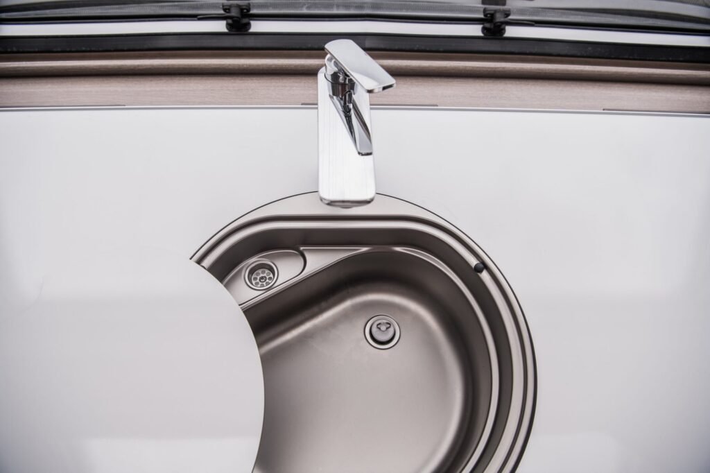 A bottle of RV drain cleaner sits near a clean recreational vehicle valve.