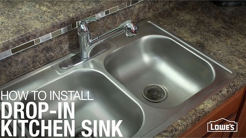 A professional installer applies clear sealant to a new kitchen sink countertop.