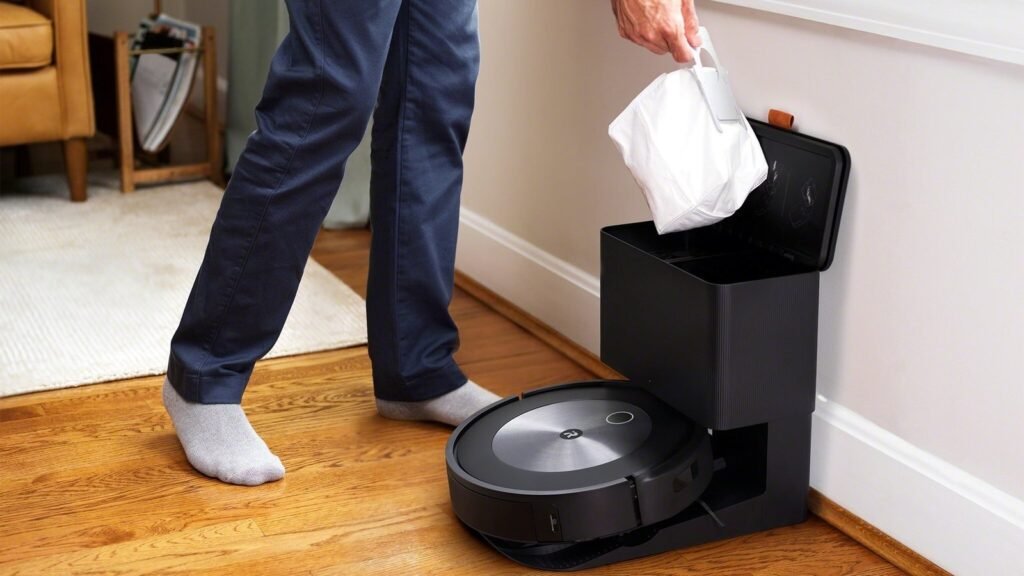 A modern self-emptying robot vacuum parked in a bright, clean living room space.