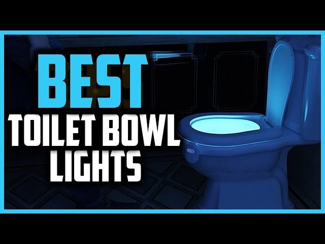 A glowing motion-sensor night light illuminates a modern toilet in a dim bathroom.
