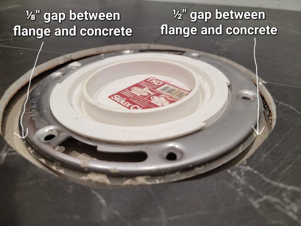 A skilled plumber installs a durable toilet flange into a concrete bathroom floor.