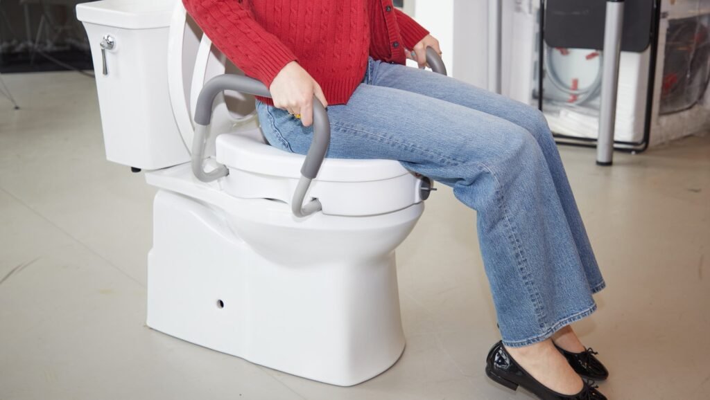 A modern toilet seat lift installed in a bright and accessible home bathroom.