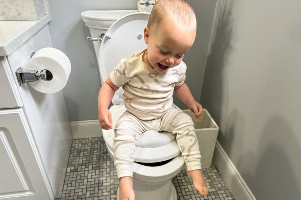 A modern toddler toilet seat installed in a clean and bright home bathroom.