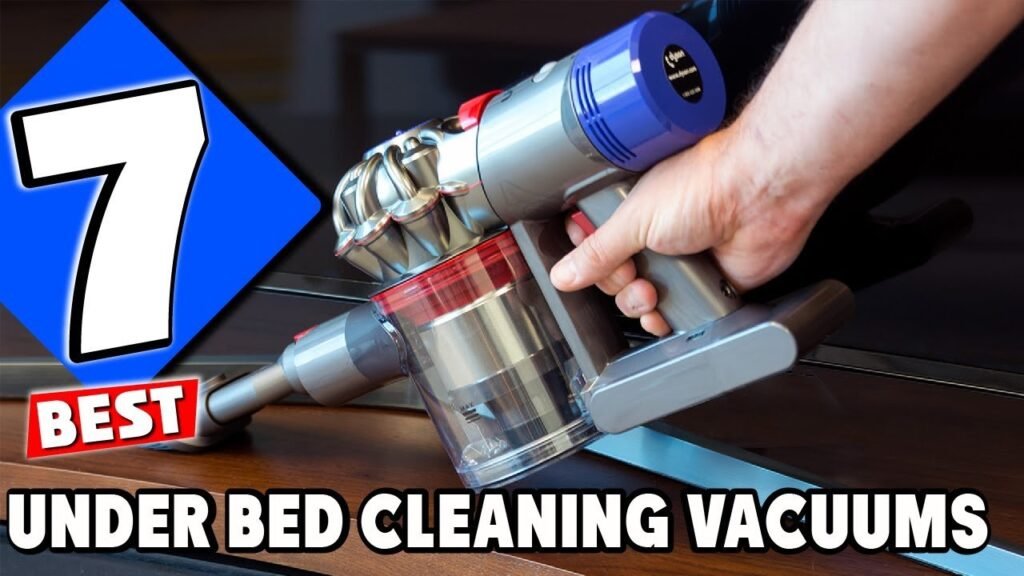 A slim cordless vacuum cleaning underneath a modern bed frame on hardwood floors.