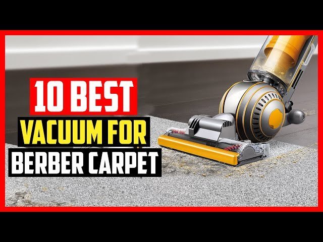 A modern vacuum cleaner sits on a clean Berber carpet in a bright room.