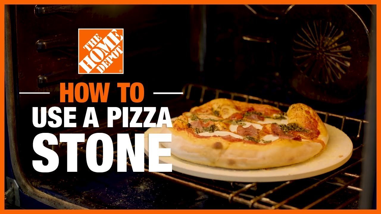 A pizza stone sitting on a wooden surface next to recipe cards.