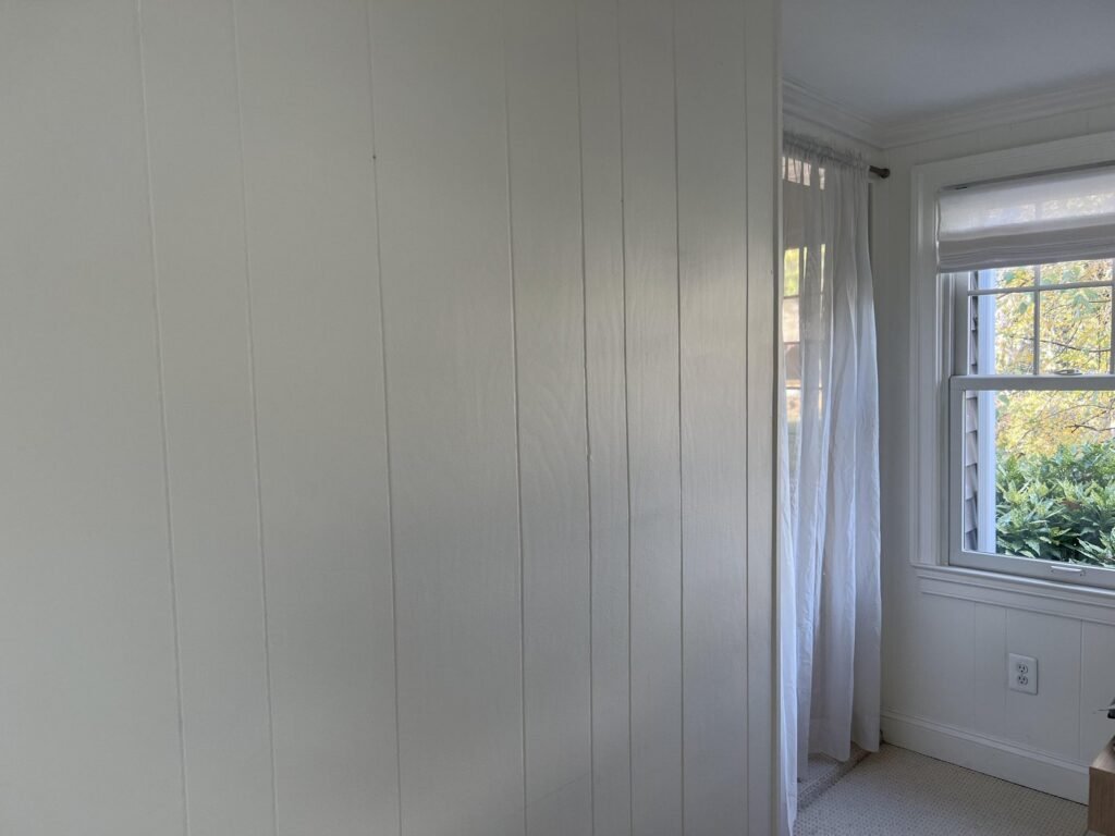 A modern room featuring bright white painted wood paneling and soft natural light.
