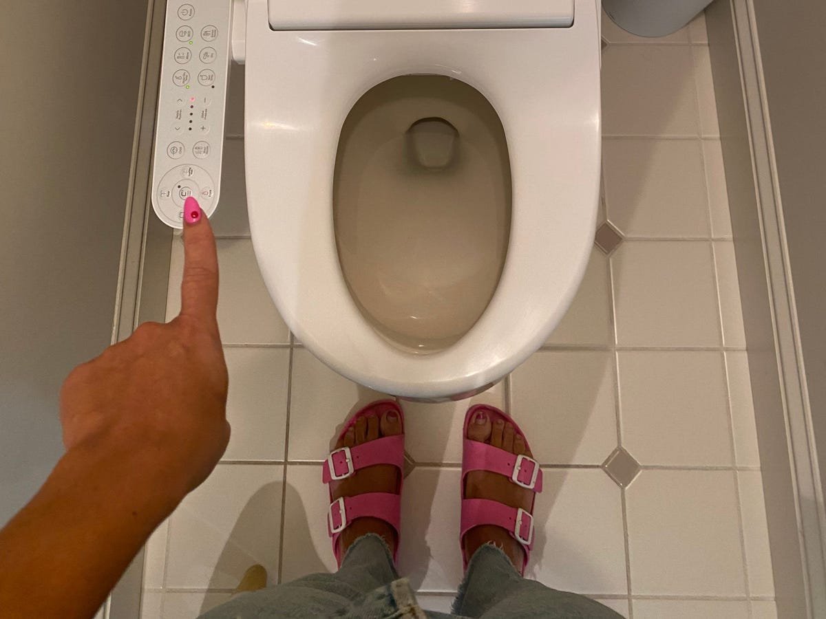 A person reads a tablet in a modern bathroom during a frequently asked questions session.