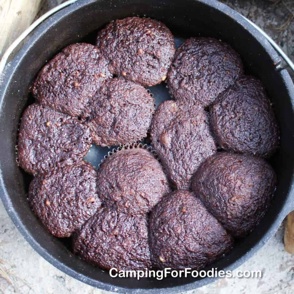 Essential baking tools and a cake tin arranged on a camping site.