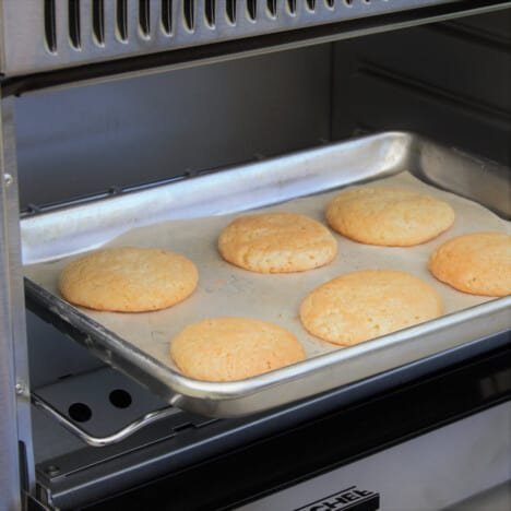 Preparation items for baking cookies next to a camping oven on a table.
