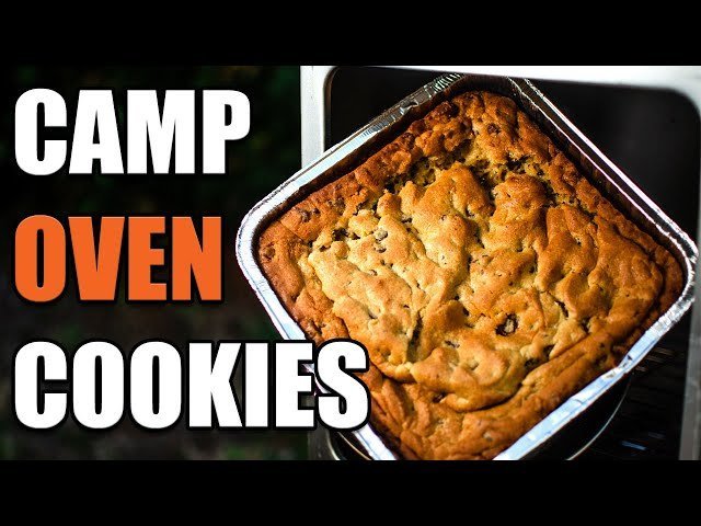 Freshly baked chocolate chip cookies inside a portable camping oven at a campsite.