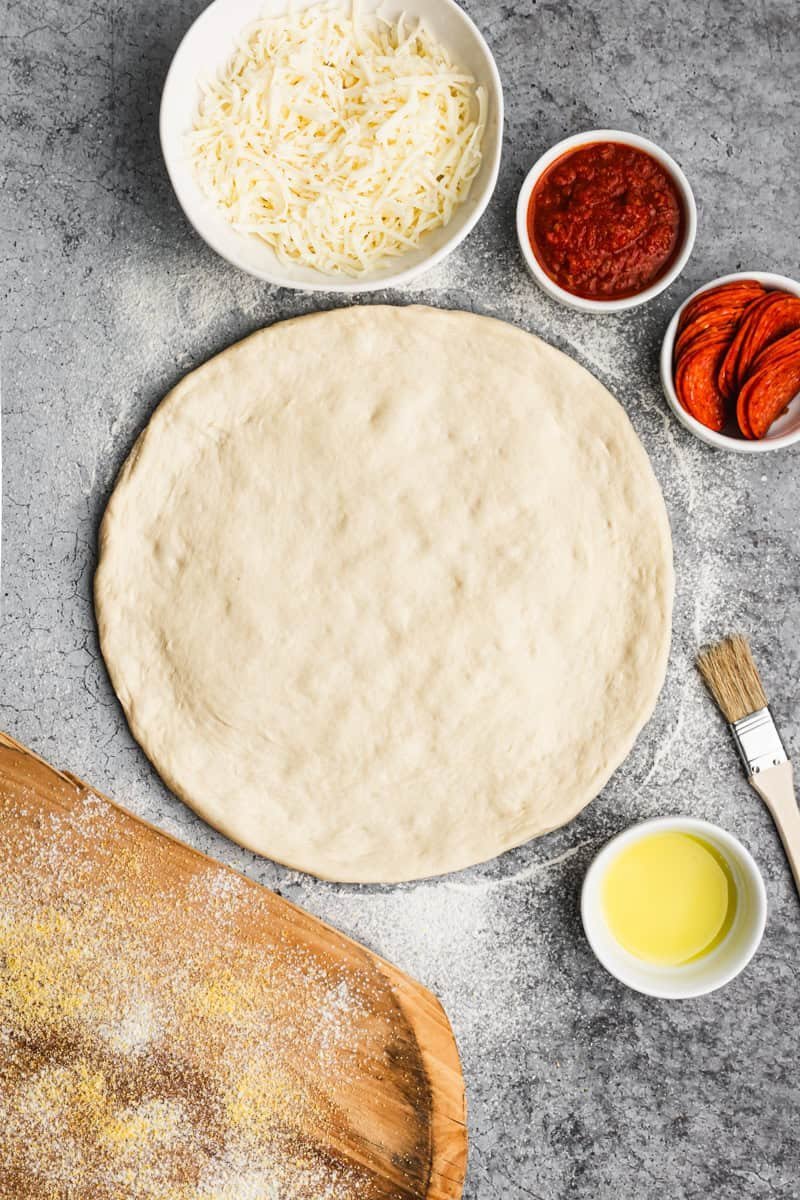 Cleaning a pizza stone with a wire brush after cooking a pizza.