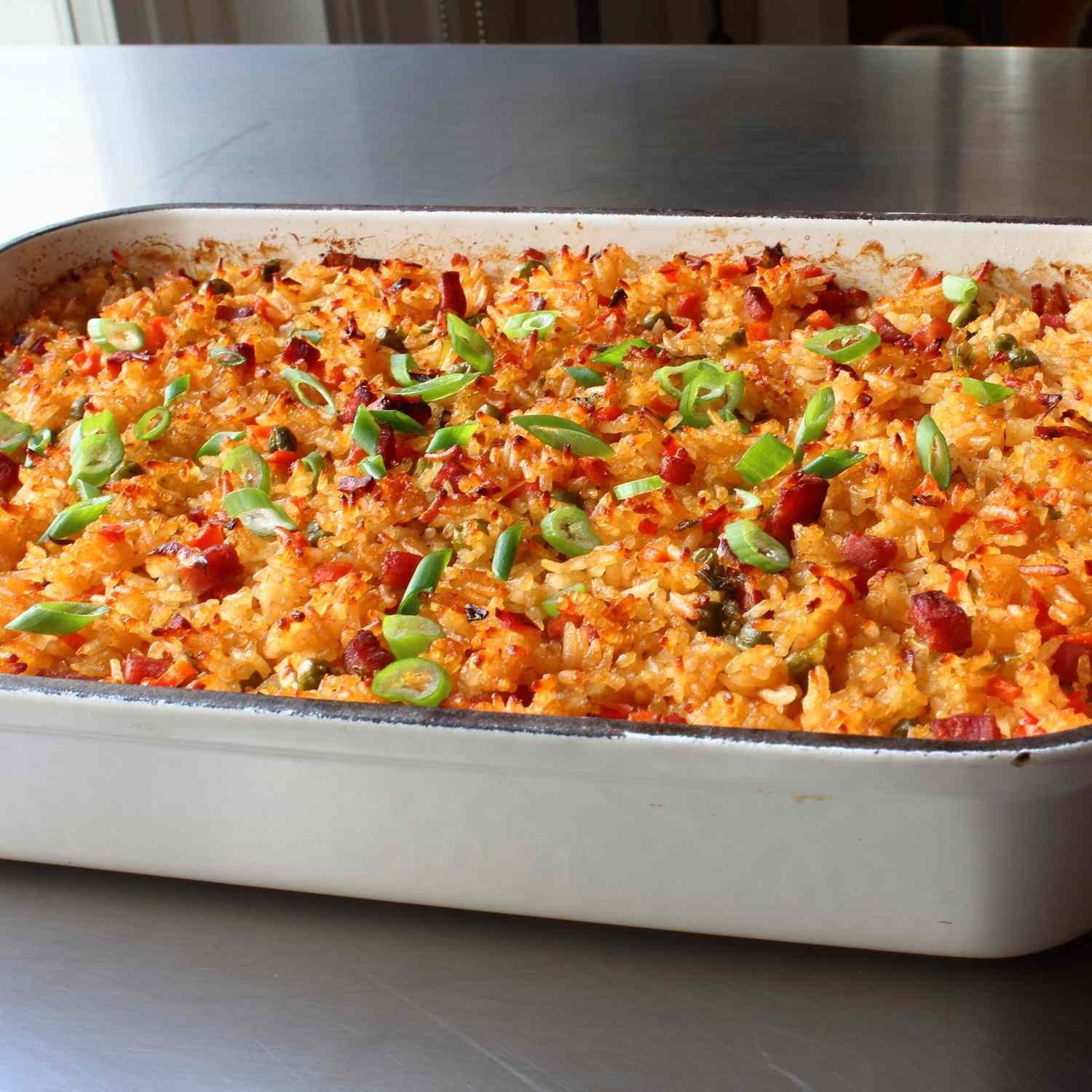 Spreading cooked rice on a tray to cool before storing it for later.