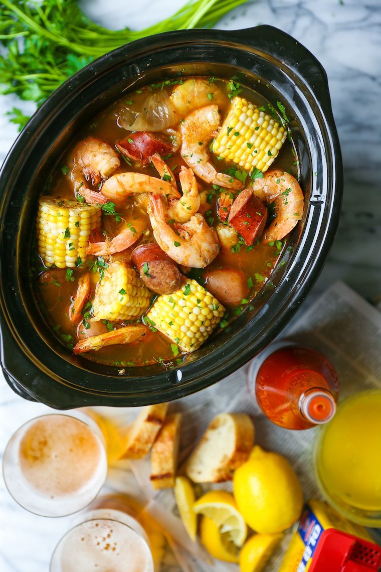 A person placing a fresh fish fillet into a clean slow cooker.