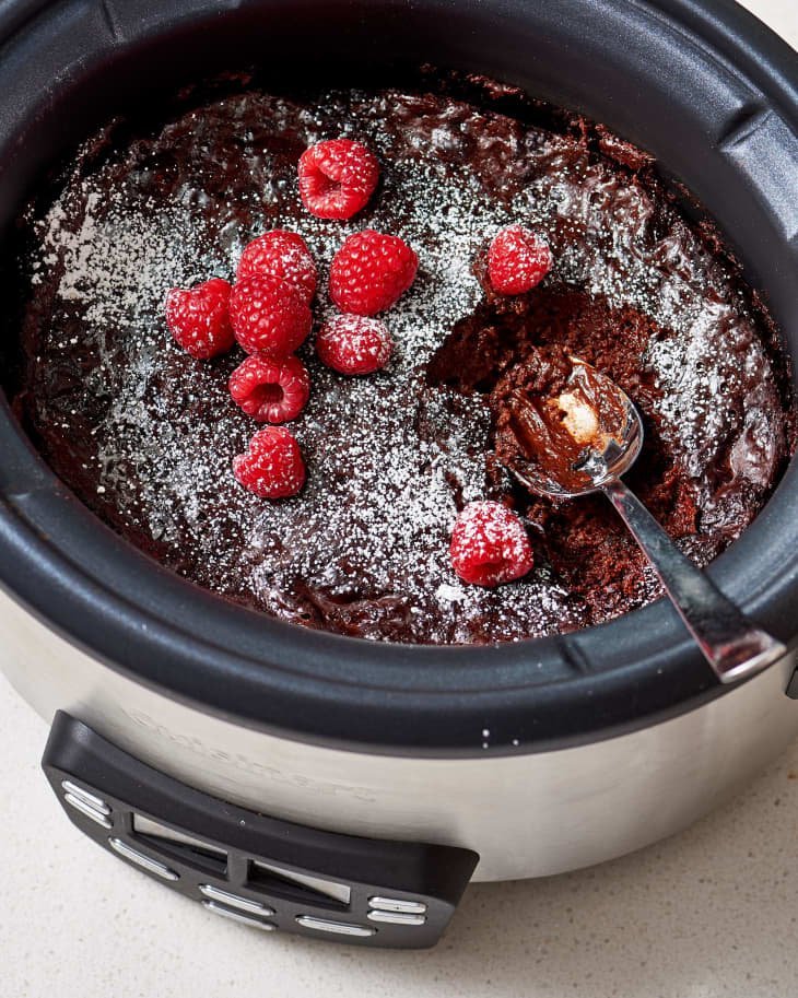A home cook preparing a dessert in a slow cooker to save oven space.