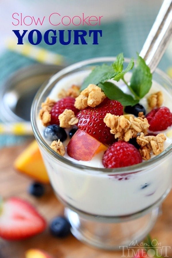 Several glass jars filled with freshly made yogurt arranged on a wooden table.