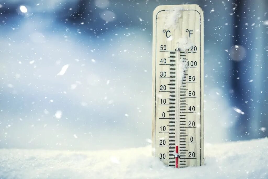 A modern outdoor thermometer mounted on a wooden wall for accurate temperature monitoring.