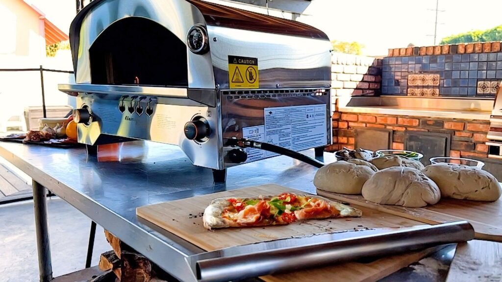 A modern outdoor pizza oven fueled by propane on a backyard patio.