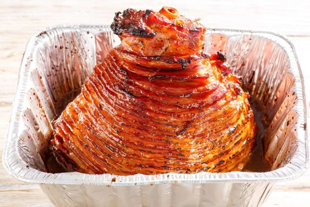 A beautifully roasted glazed ham prepared for cooking in an infrared oven.