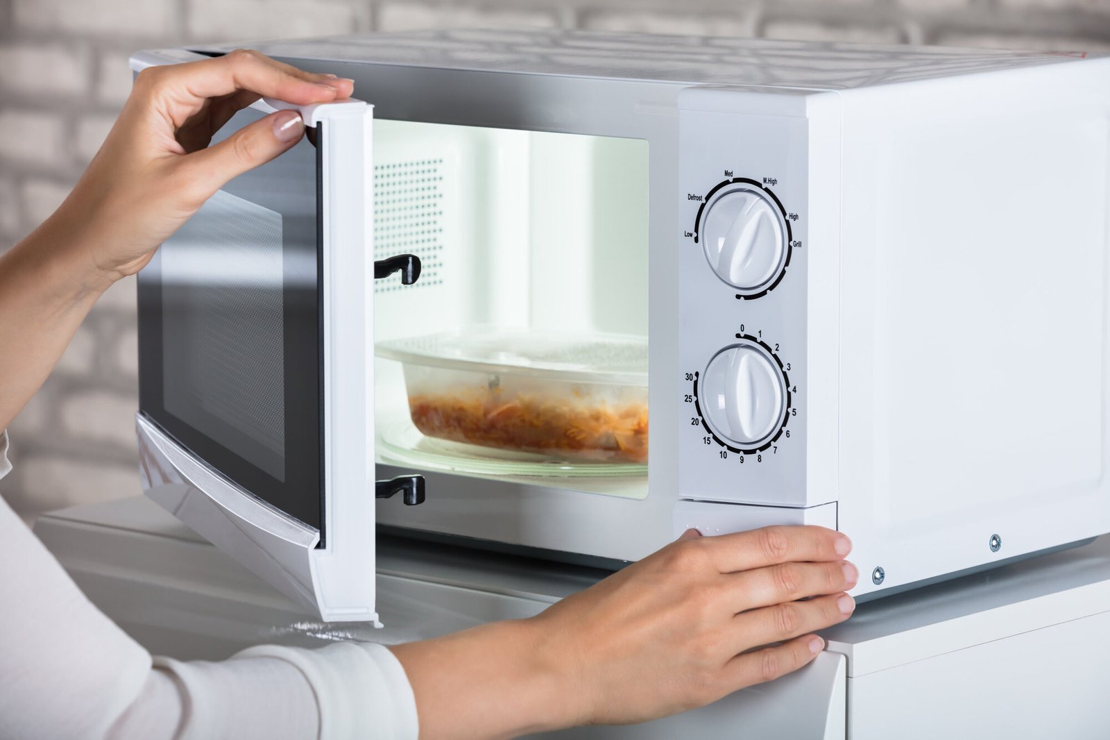 A clean cloth wiping the interior surface of a modern oven.