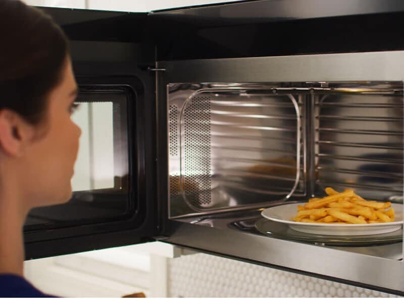 A frozen chicken breast sits on a baking tray ready to defrost.
