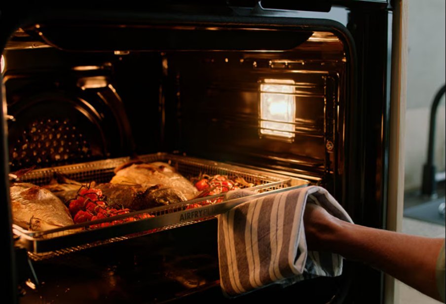 The glowing red heating element of an oven broiler seen from inside.