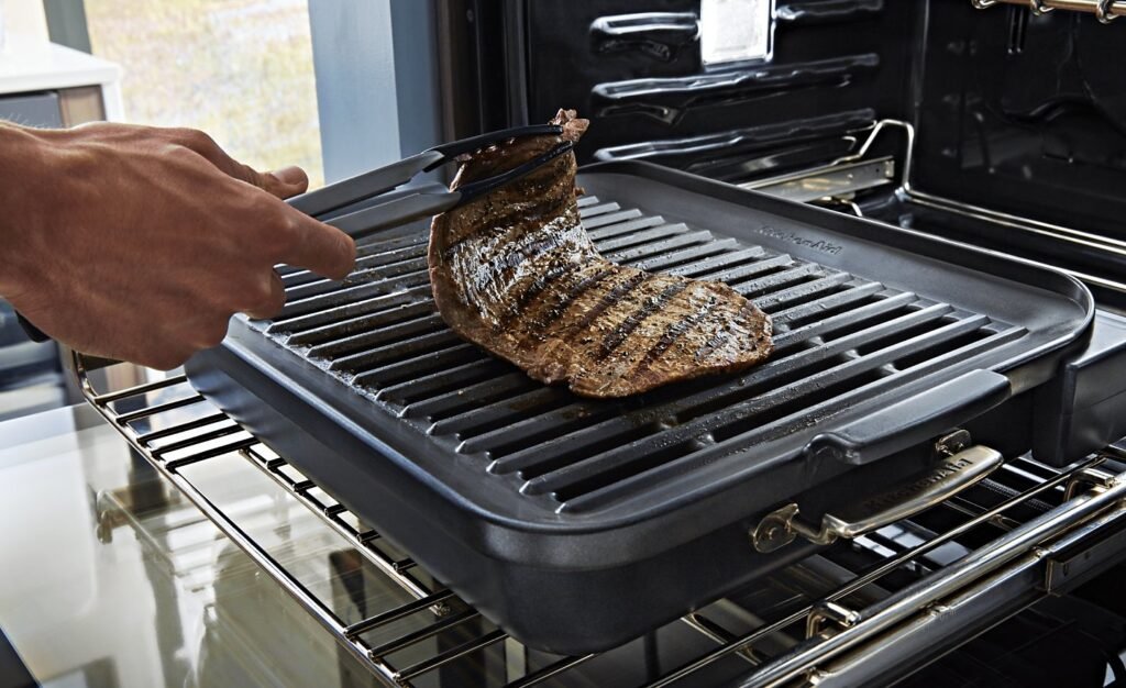 A juicy ribeye steak searing under the intense heat of an oven broiler.