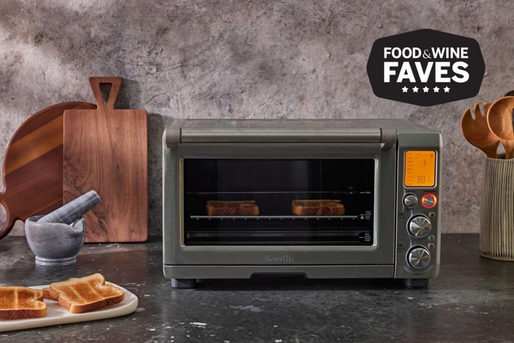 A modern stainless steel oven sits in a bright, clean kitchen.