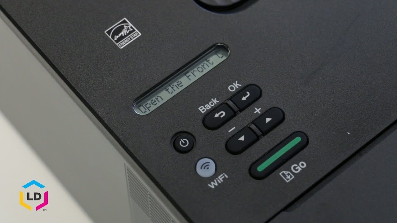 A printer control panel displaying a flashing warning icon for low ink levels.