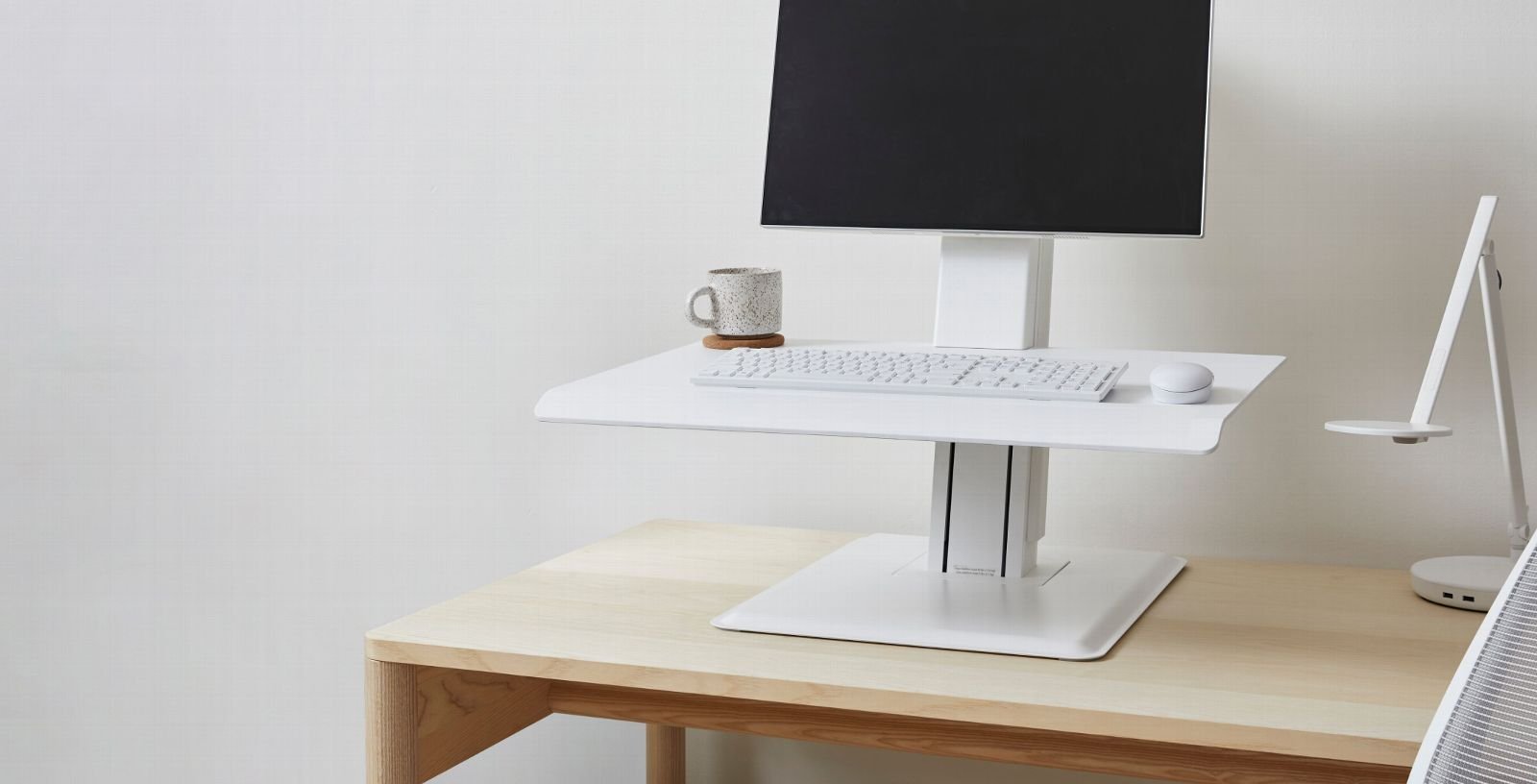 Measuring the clearance for a standing desk near a wall outlet.