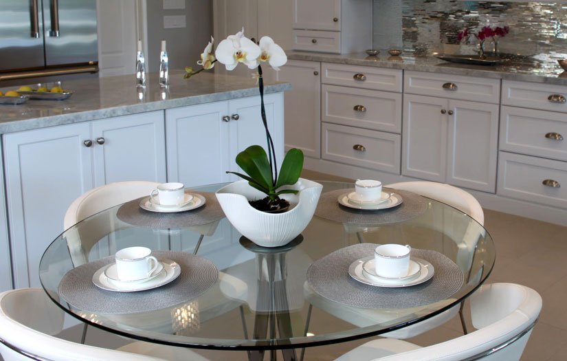 A beautifully styled glass table centerpiece with linen runner and decorative accents.