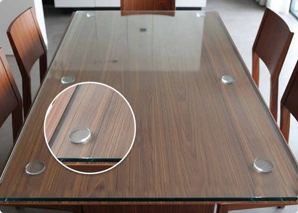 A large glass tabletop stands against a wall, ready for safe disposal preparation.