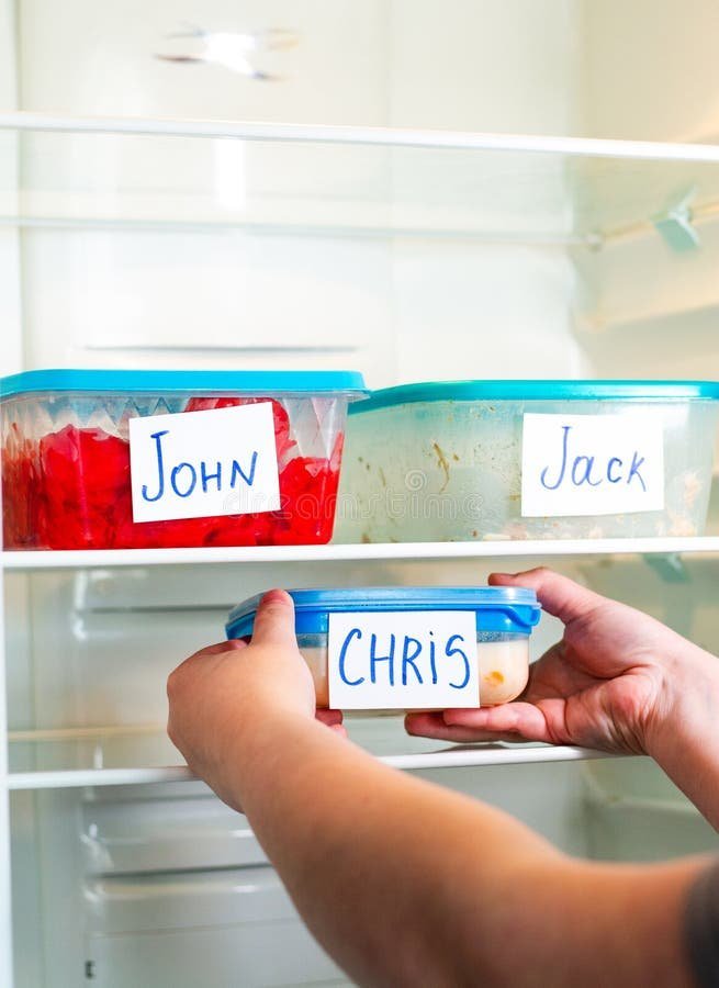 Applying a blue painter's tape label to a container for office freezer storage.